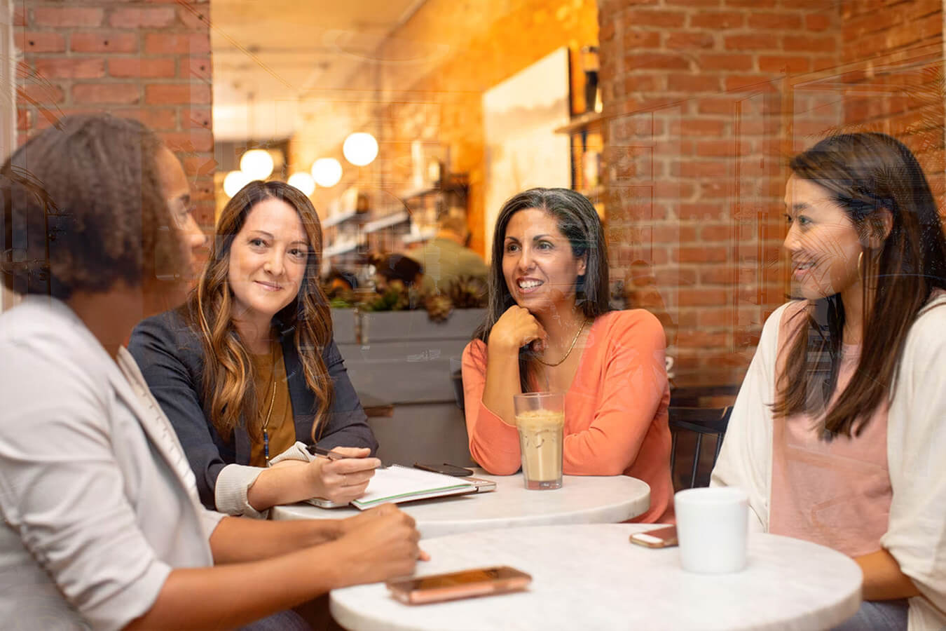 a group of women drinking coffee and discussing ideas